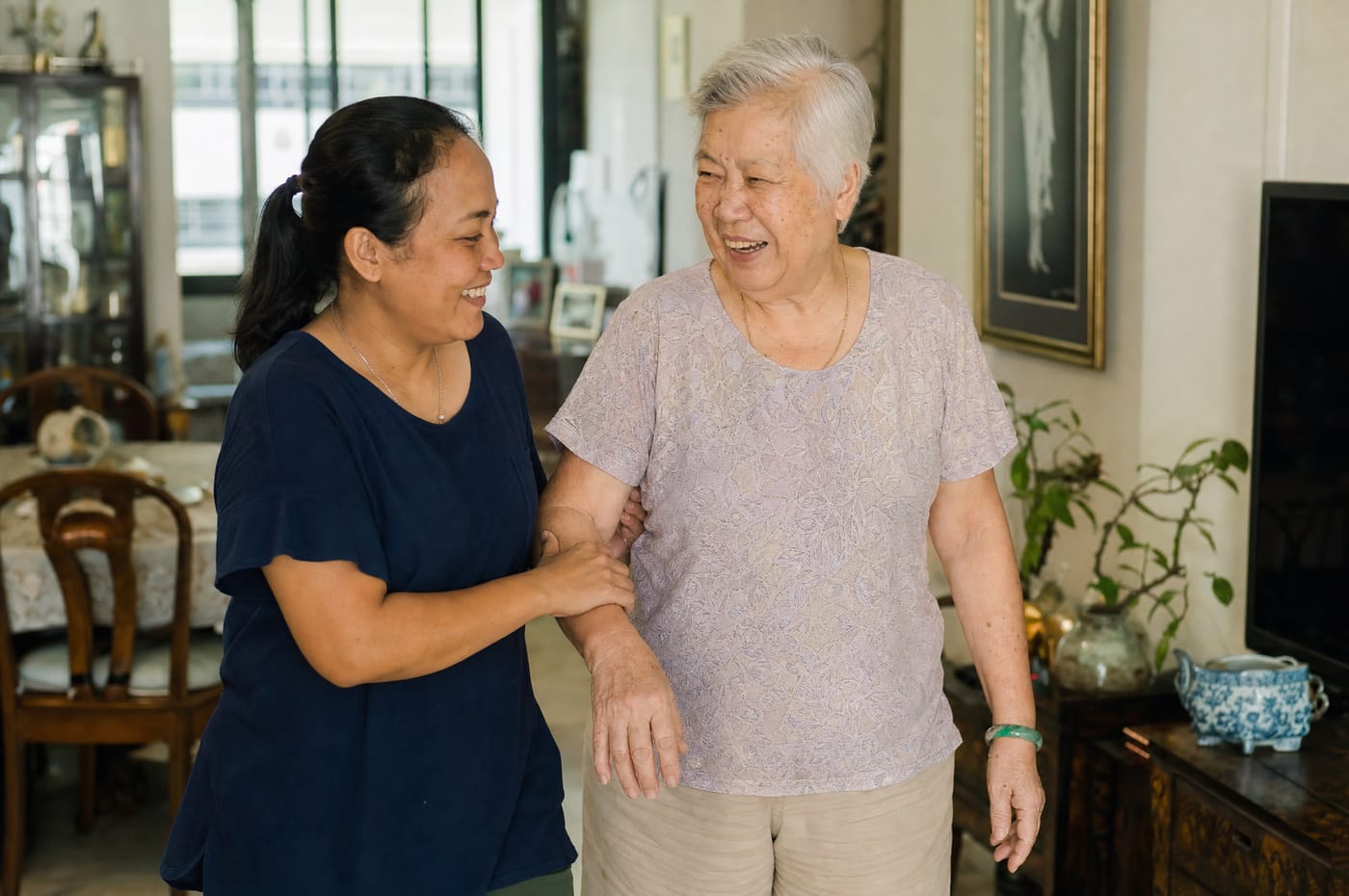 A helper caring for an elderly woman